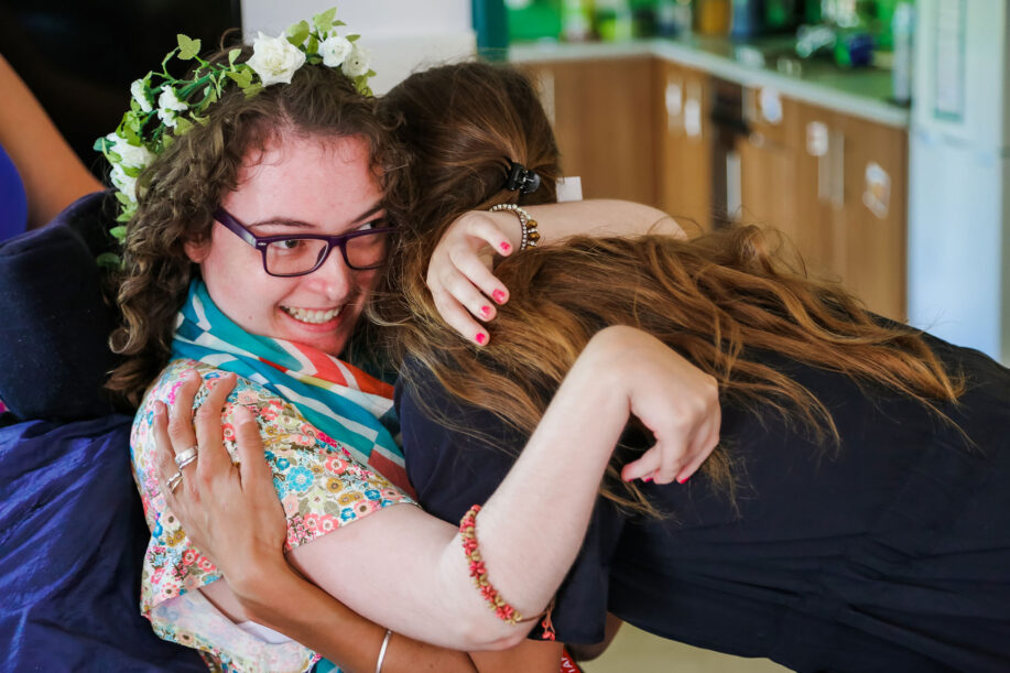 Young lady in a wheelchair hugging another lady