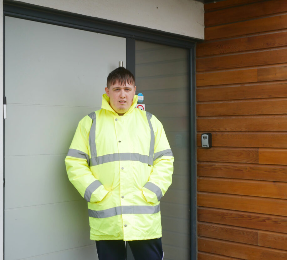Isaac wearing his work uniform, a reflective jacket