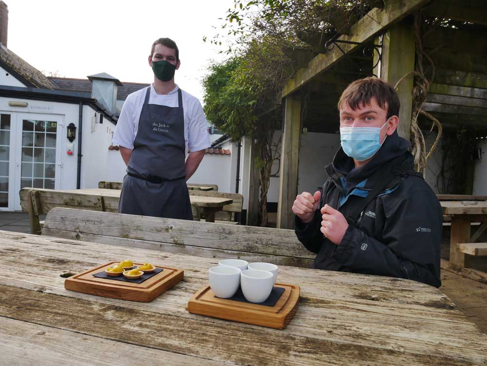 Craig the chef with Ruairi outside the pub. The cups of soup and the tartlets are on boards in front of them.