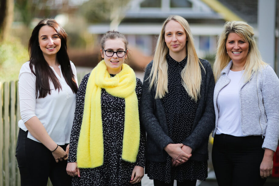Four women stood next to each other outside