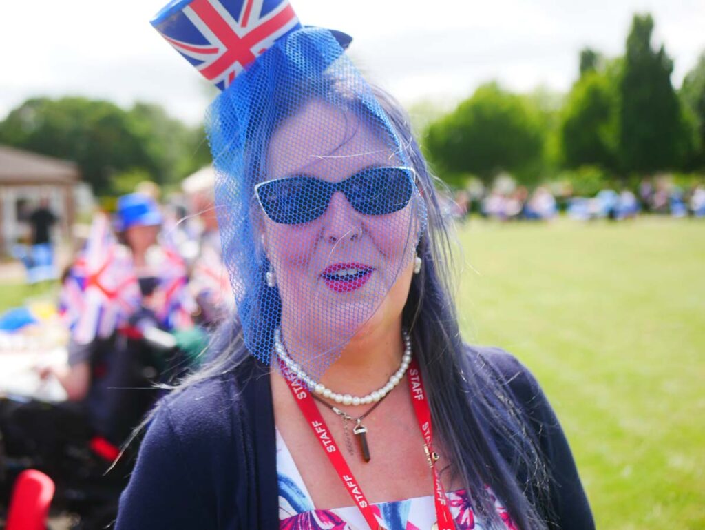 Lady in glasses wearing a union jack flag with a blue veil