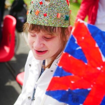 Young lady in a crown holding a union jack flag