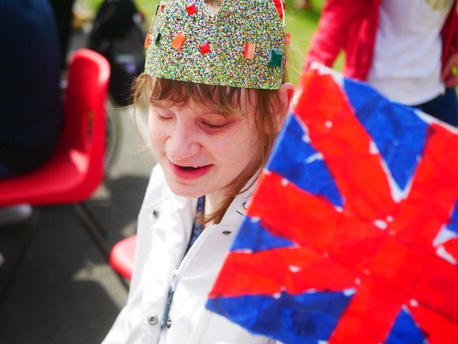 Young lady in a crown holding a union jack flag