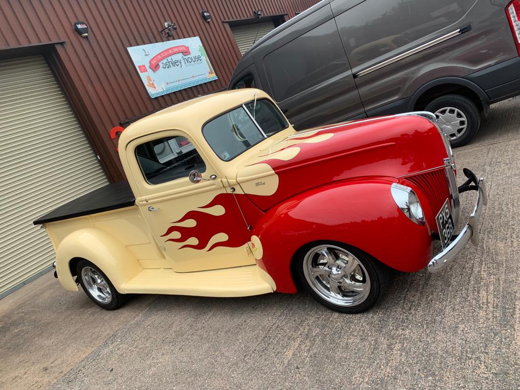 Cream coloured classic truck with red flames painted at the front