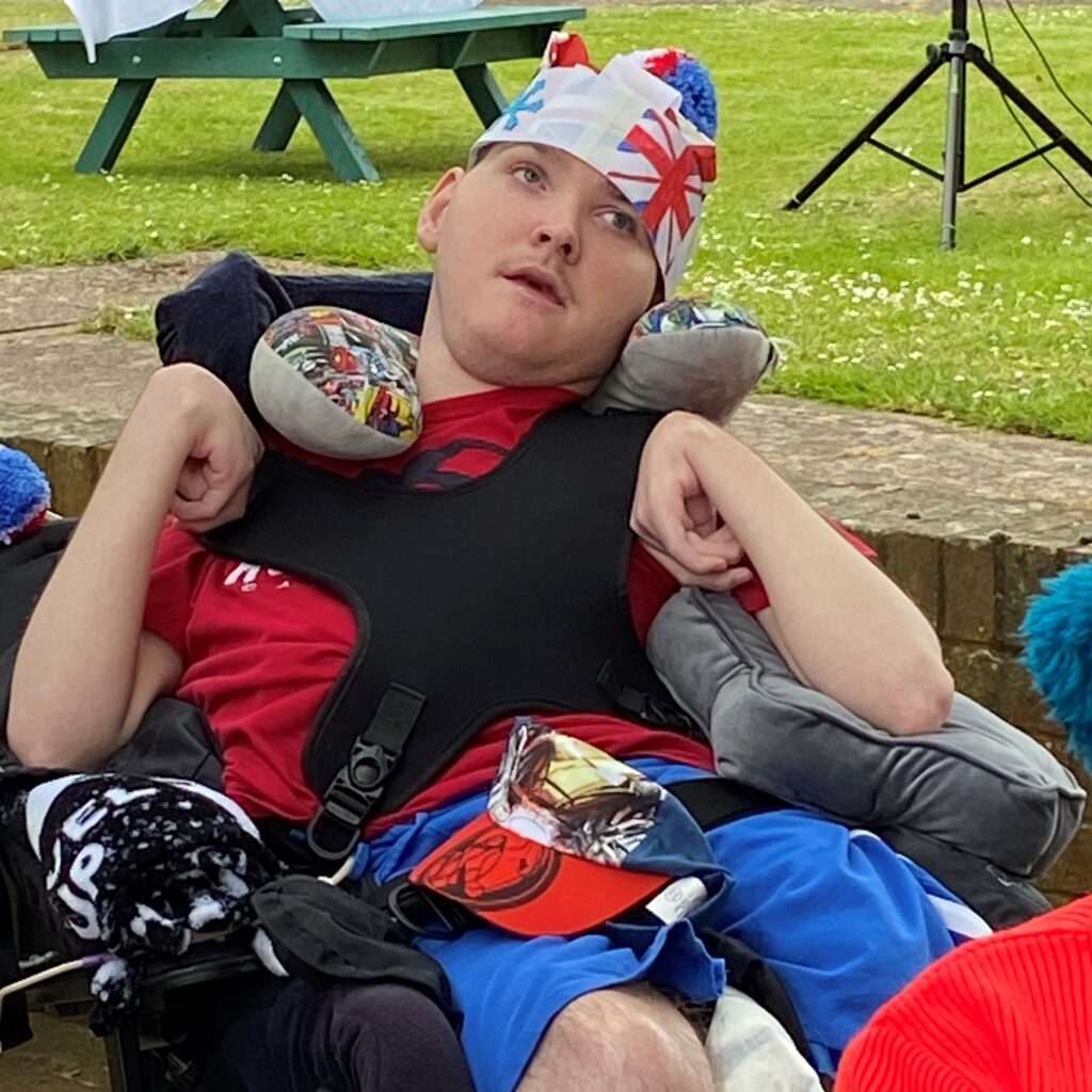 A young man wearing a union jack hat.