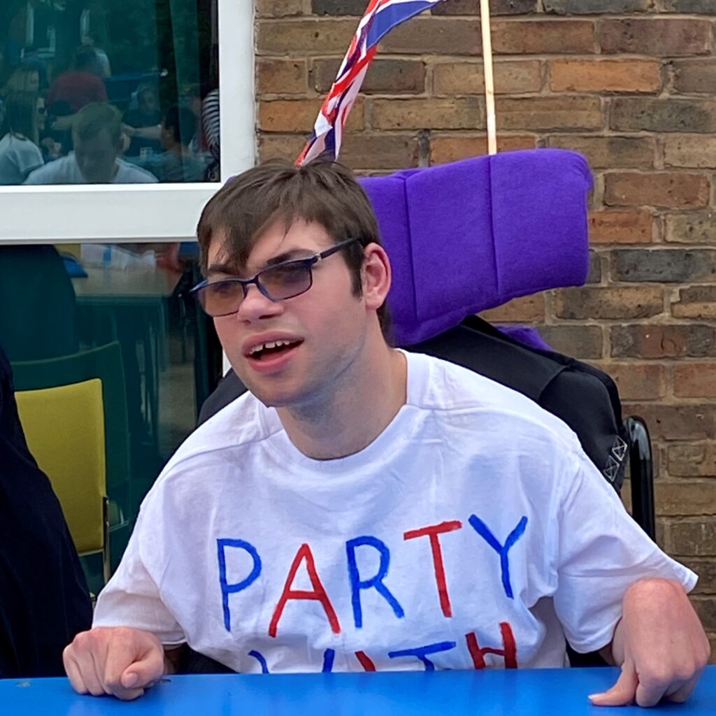 A young man wearing a t-shirt which says 'party'.