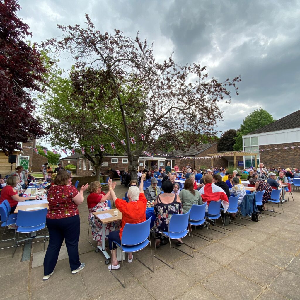 a photo showing the lots of people sat around long tables, enjoying the InFocus Coronation party