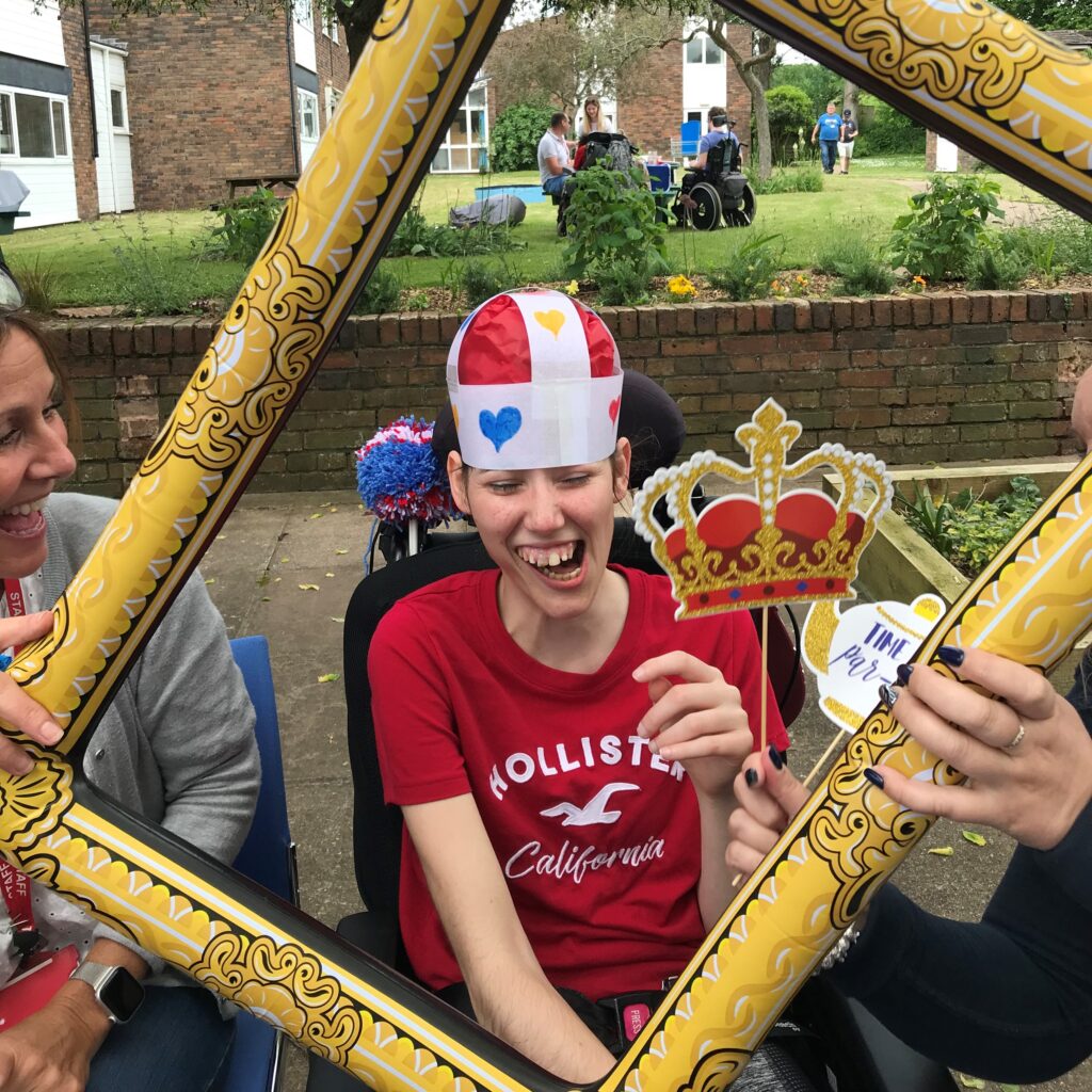 A young person posing for a photo through a blow up frame.