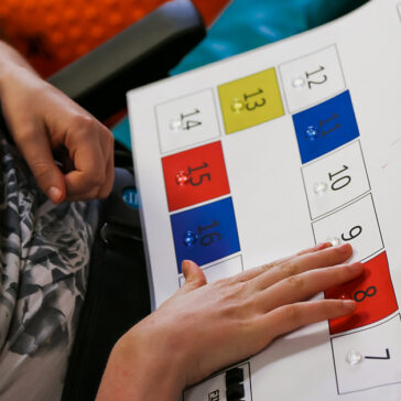 Fingers pointing at a board with numbers
