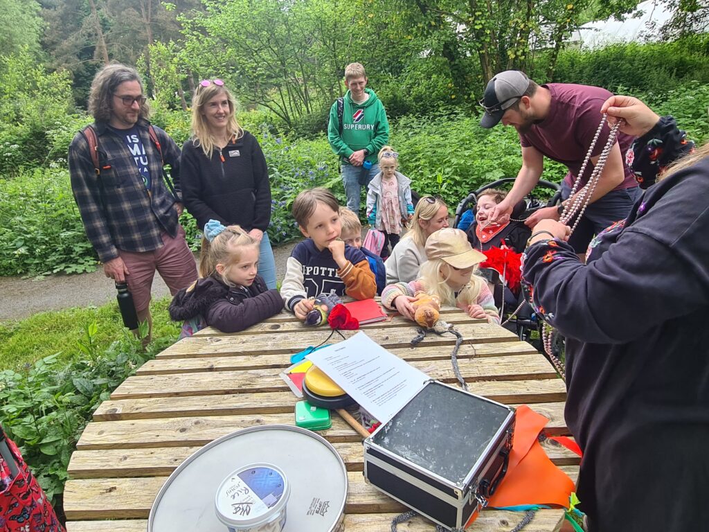 Children and families sat around a table outside.