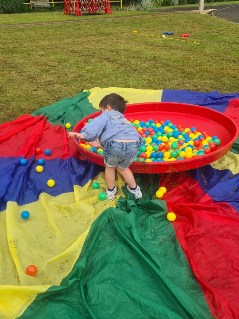 A boy plays in a ball pool.