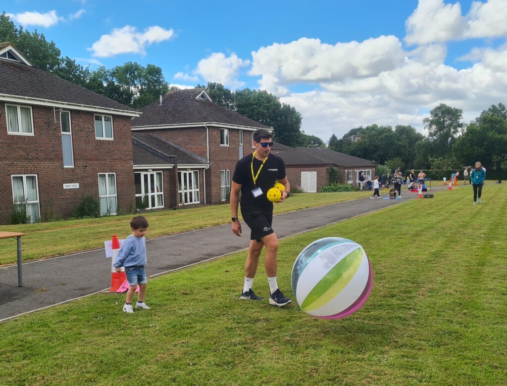 a man is kicking a large inflatable ball.