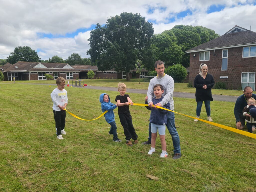 Children and an adult play tug of war