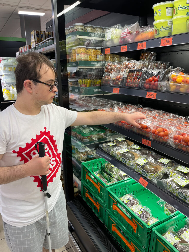 A young man shopping for tomatoes in a supermarket