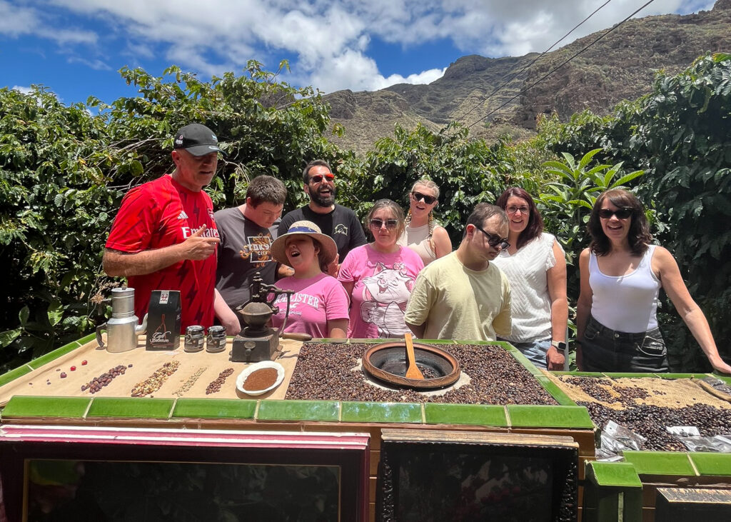 A group shot of adults and young people at a coffee plantation.