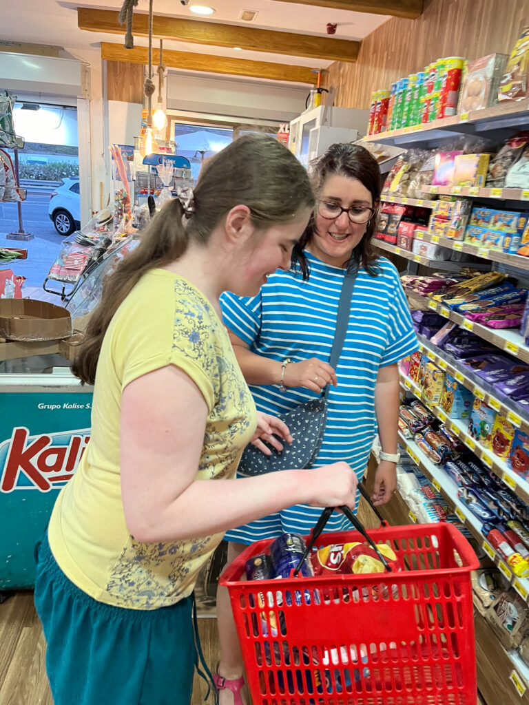 A young woman and a woman shopping in a food store.