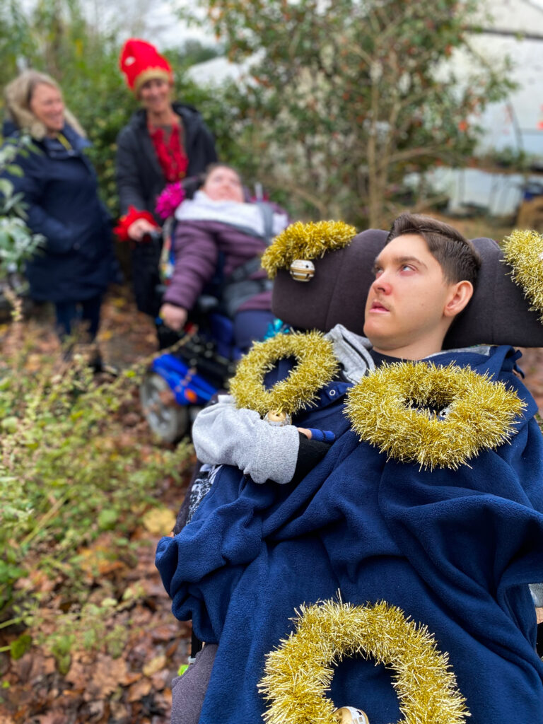 a young adult sat in a wheelchair with two gold rings on him