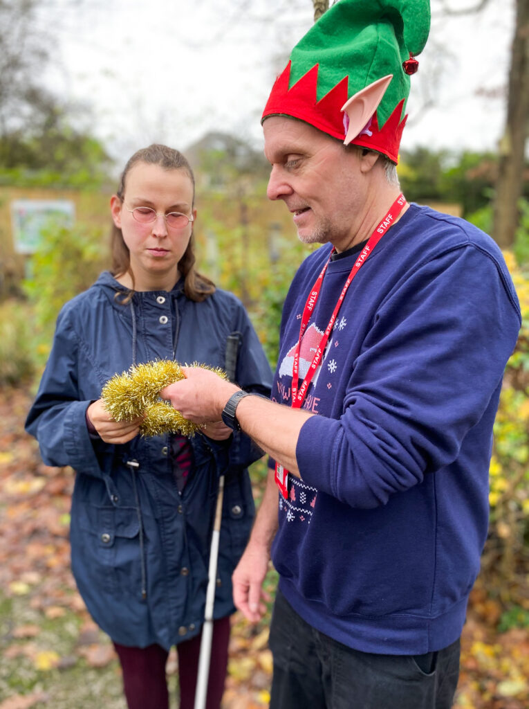 A young adult and a support worker with a gold ring.