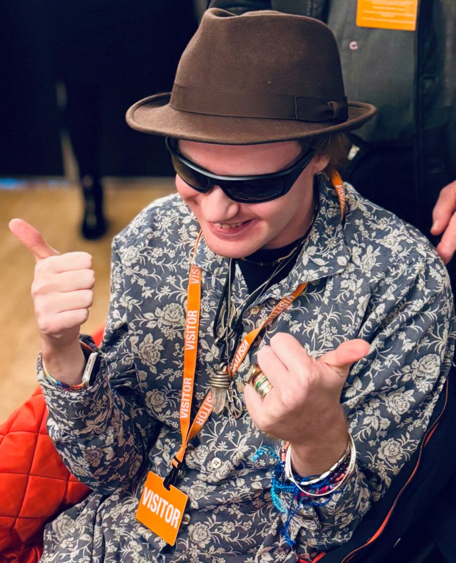 A young man. He's smiling with his thumbs up.