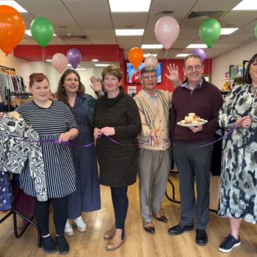 A group photo taken in a charity shop