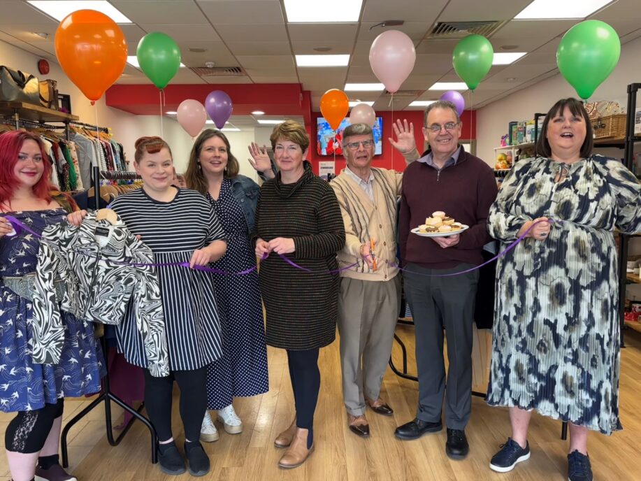 A group photo taken in a charity shop
