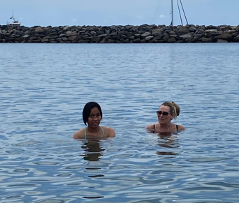 a student and member of staff swimming in the sea