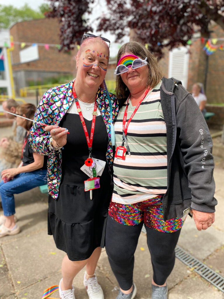 two members of staff dressed for Pride!