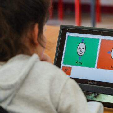 A student looking at a screen. There are two options on the screen - yes and no.